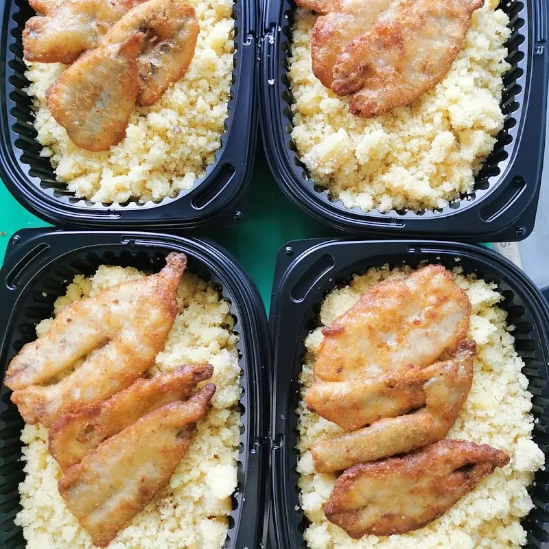 Cuatro raciones para llevar de pescado frito empanado sobre una guarnición desmenuzada