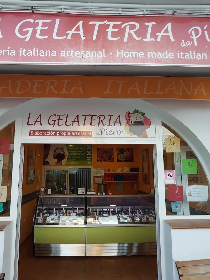 Entrada en arco con el rótulo de elaboración propia artesanal y la vitrina de helados al fondo