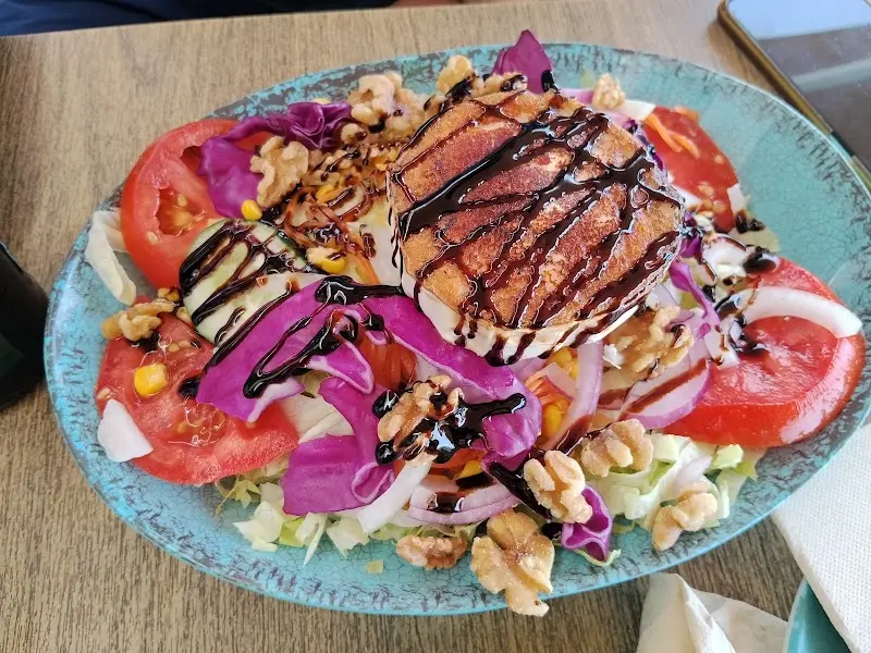 Ensalada de queso de cabra con nueces, lombarda, tomate y reducción de vinagre