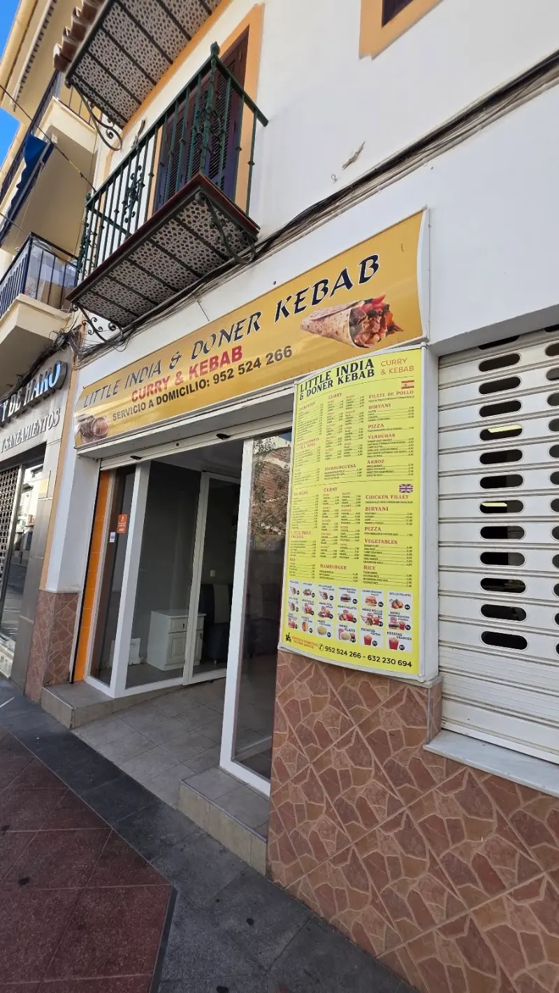 Local de Little India & Doner Kebab con rótulo amarillo, teléfono y carta en la fachada