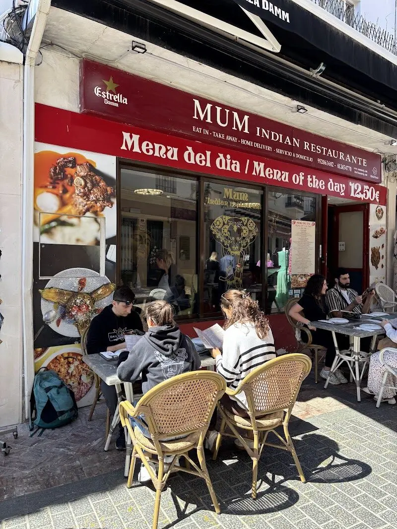 Terraza soleada de Mum Nerja con clientes y el cartel del menú del día a 12,50 €