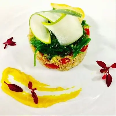 Timbal de cereal con tomate, alga wakame y láminas de calabacín con salsa amarilla