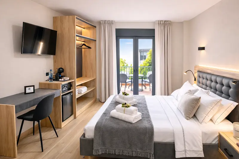 Habitación de NerjaRooms con cama de matrimonio, escritorio, televisor y balcón con mesa