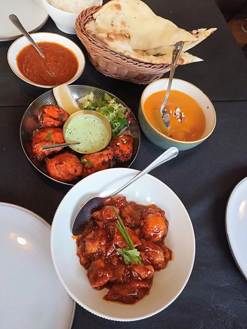 Pollo tikka con salsa de menta, curry rojo, crema de calabaza y cesta de pan naan