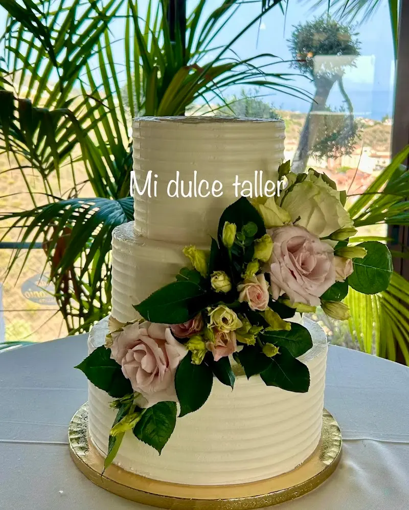 Tarta nupcial de tres pisos de crema blanca adornada con rosas naturales