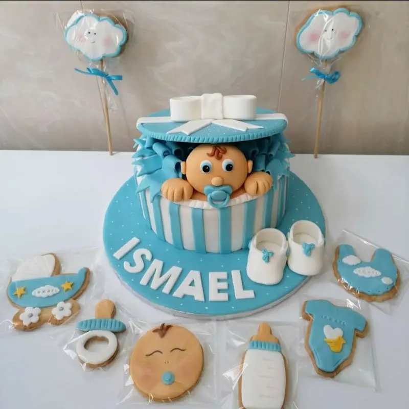 Tarta de bautizo azul con un bebé de fondant y galletas decoradas a juego