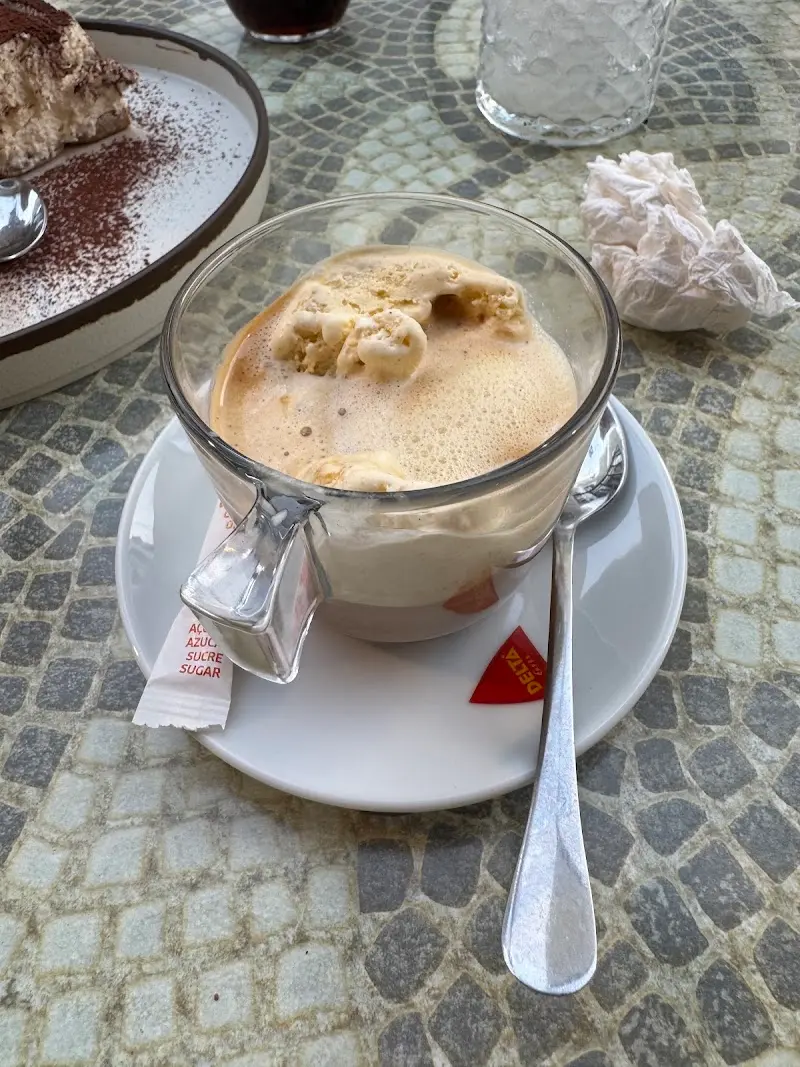 Café con bolas de helado en taza de cristal sobre una mesa de mosaico