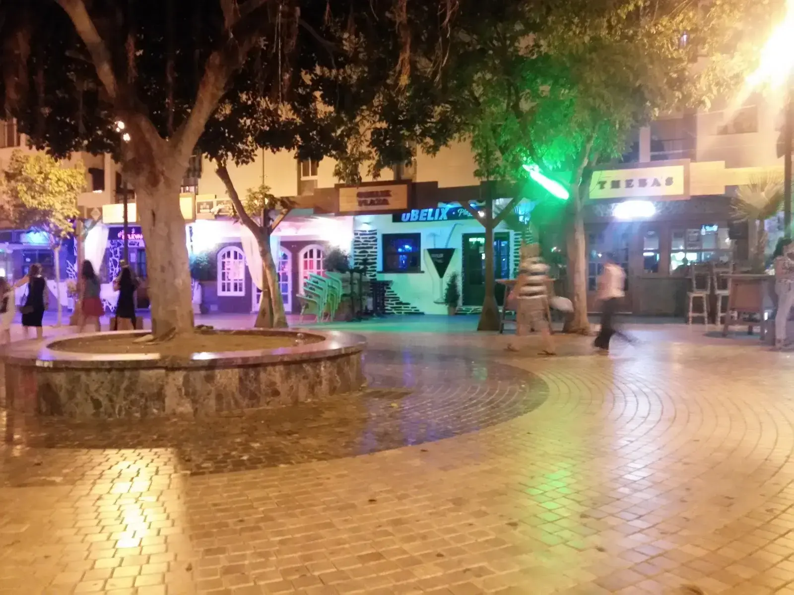 Plaza Tutti Frutti de noche, con gente paseando entre los bares iluminados