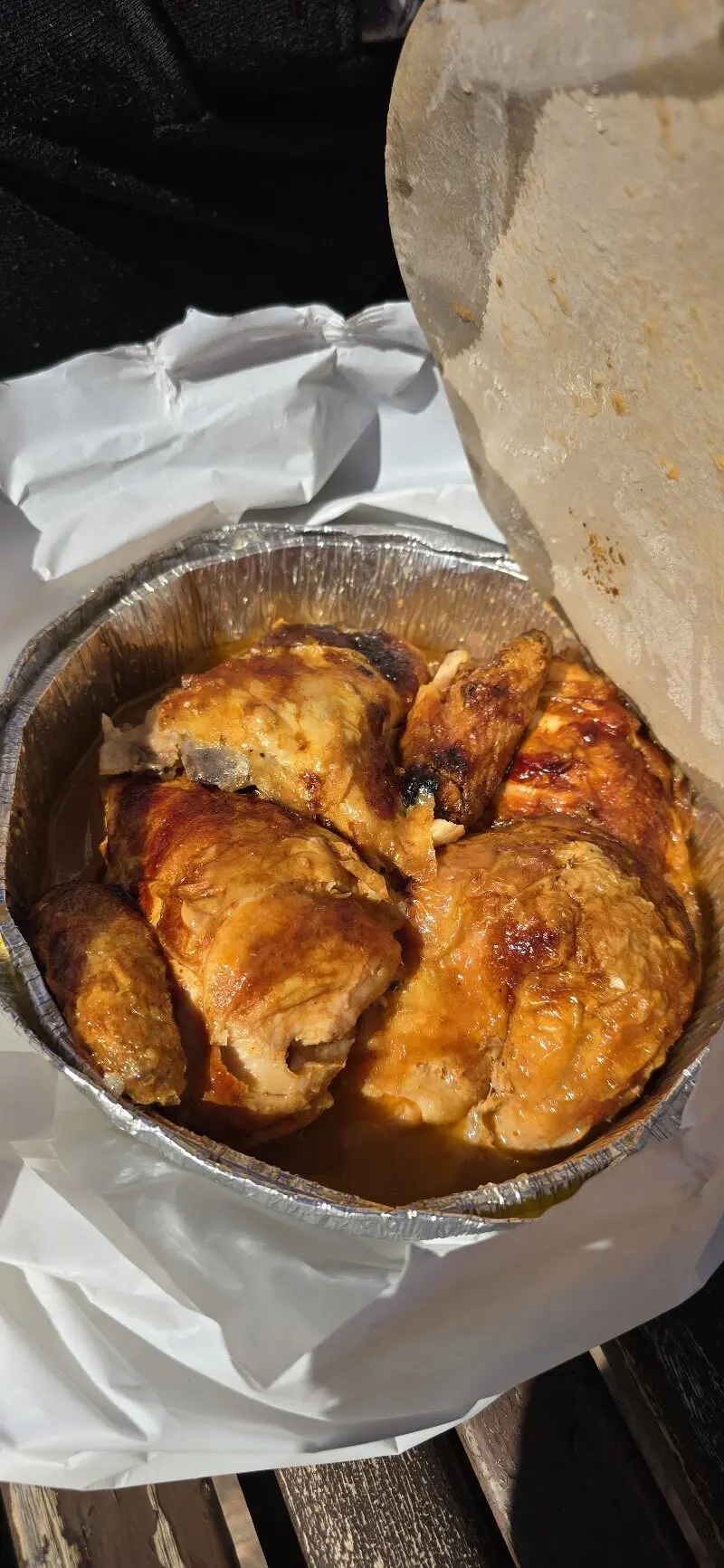 Pollo asado dorado en su jugo dentro de una bandeja de aluminio de Pollos Sirena