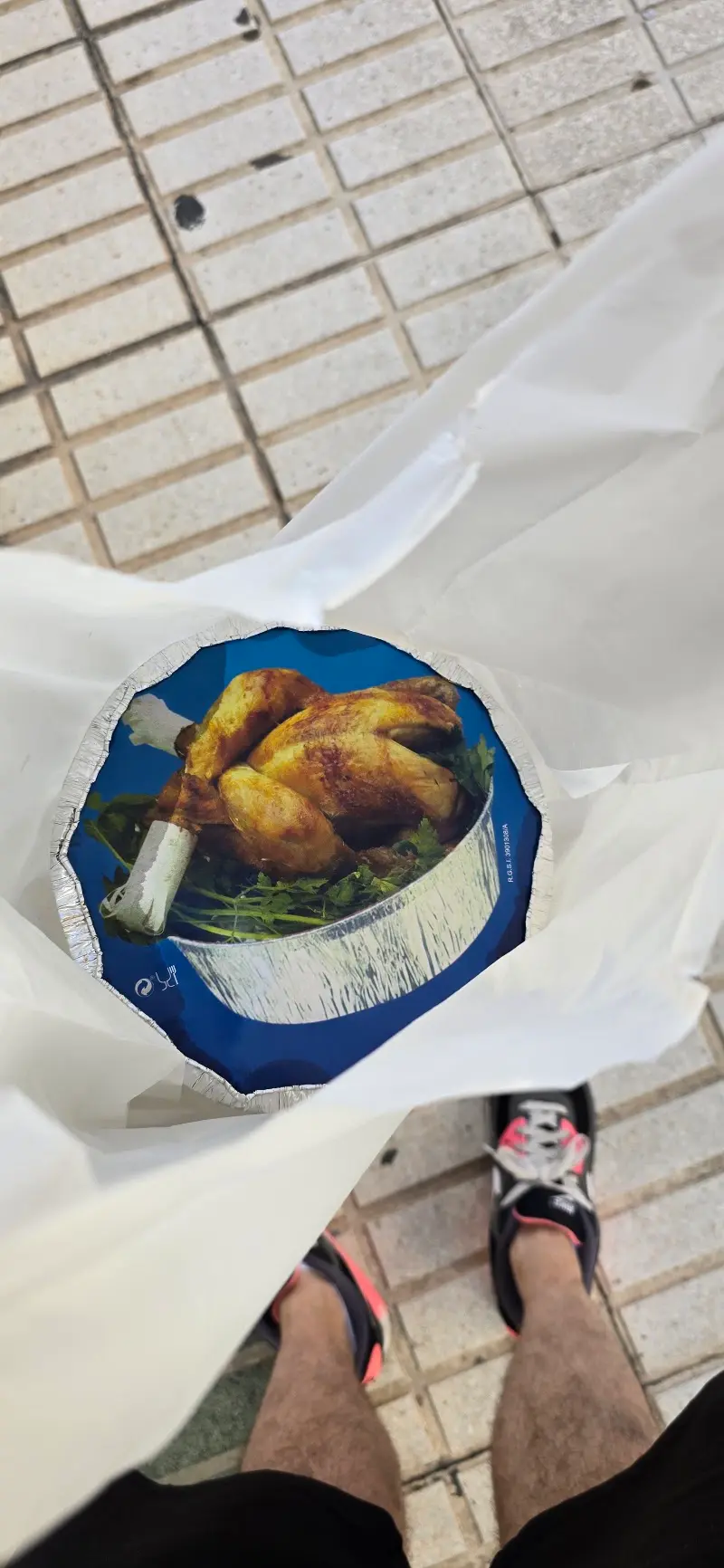 Pollo para llevar en bandeja con tapa de cartón, dentro de una bolsa blanca