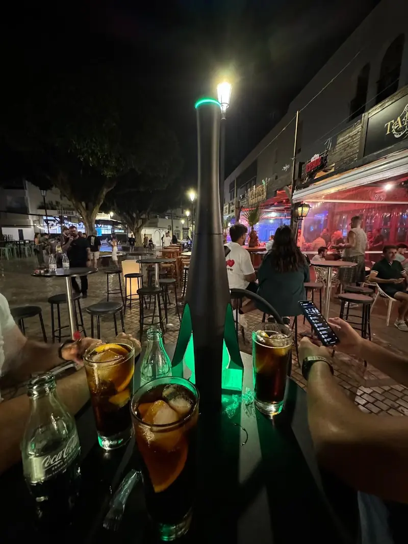 Copas en una mesa de la terraza de noche, frente al pub en la Plaza Tutti Frutti