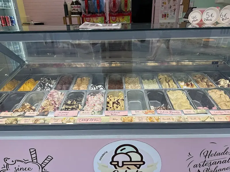 Vitrina de helados artesanos de varios sabores con sus carteles en Puerta del Mar Gelato
