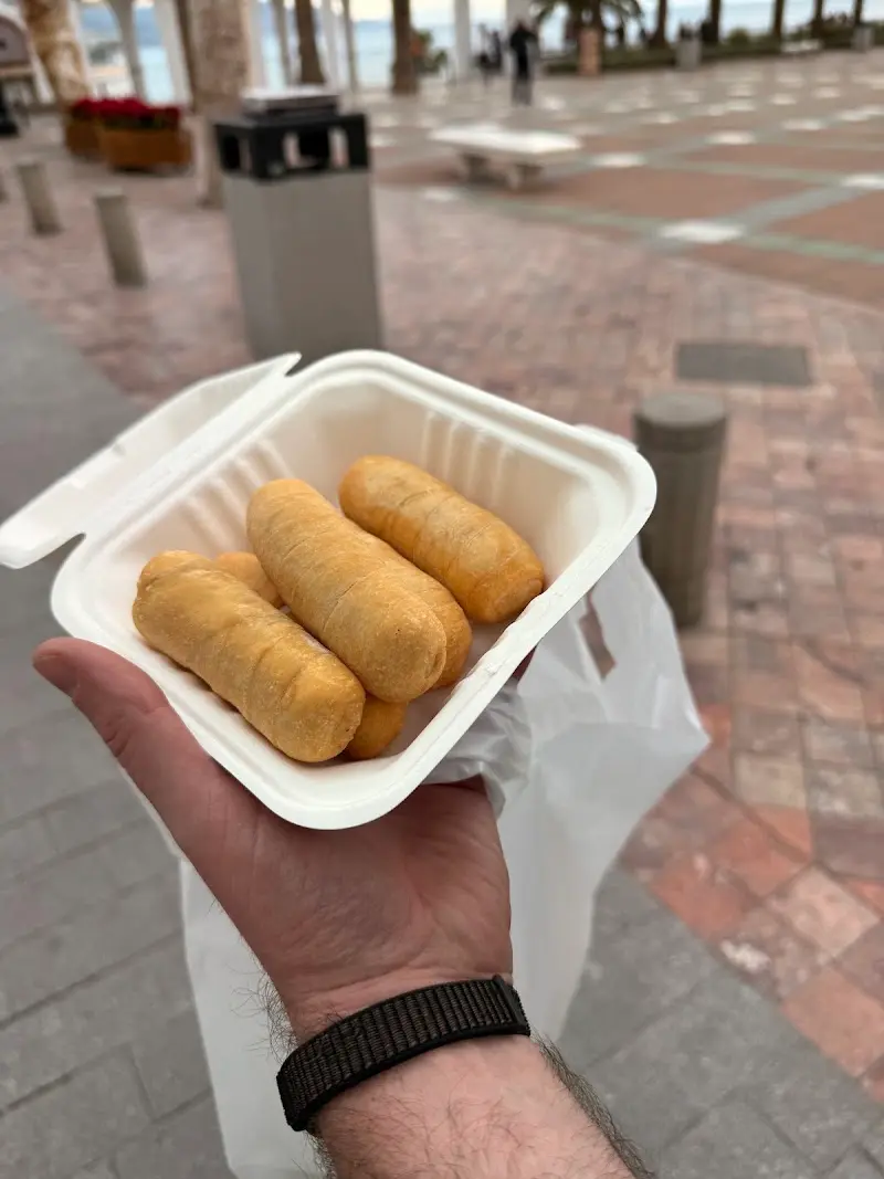 Tequeños para llevar en una caja de cartón, en un paseo junto al mar
