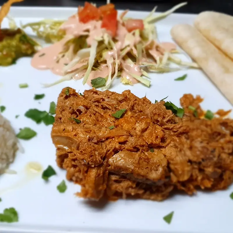 Cochinita pibil deshebrada con ensalada de col, guacamole y tortillas de maíz