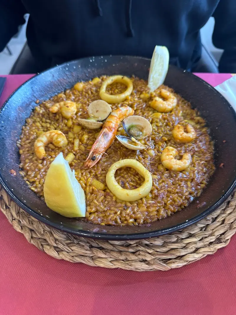 Arroz con marisco en paellera con gambas, almejas, calamar y limón