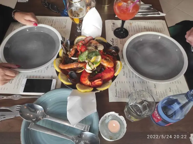 Fuente de marisco con gambas, cigalas, mejillones, almejas y limón sobre la mesa