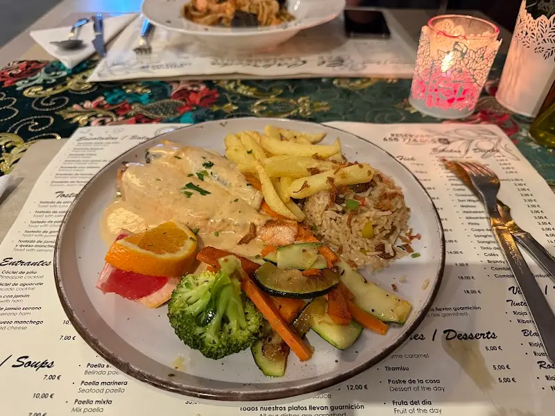 Pechuga en salsa con arroz, patatas fritas, verduras salteadas y naranja