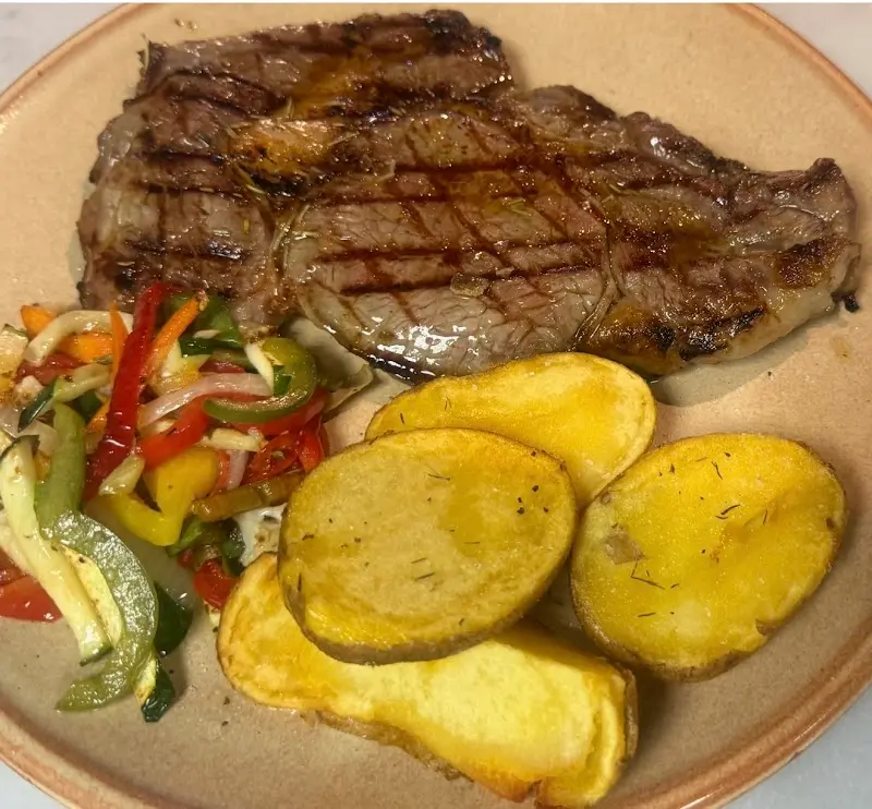 Filete a la plancha con patatas asadas y pimientos salteados