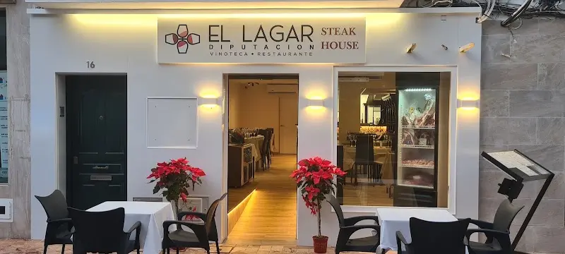 Fachada blanca en el número 16 con el rótulo «El Lagar Steak House» y mesas en la acera