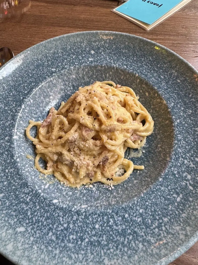 Espaguetis a la carbonara con pimienta negra en un plato hondo gris