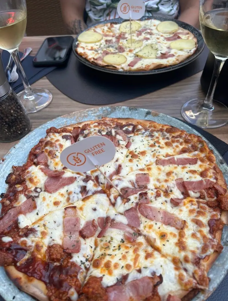 Pizzas sin gluten con jamón, beicon y patata, con sus banderitas «gluten free»