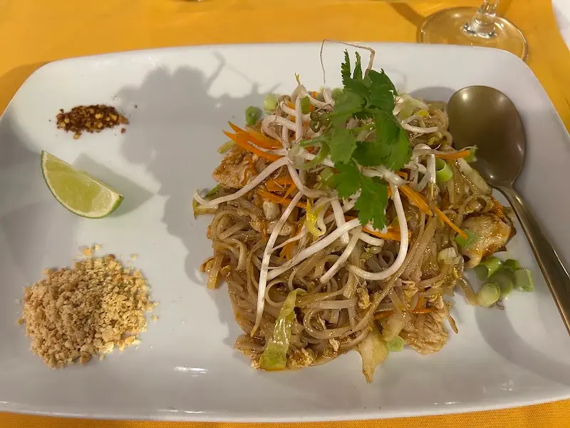 Pad thai de fideos de arroz con brotes de soja, cilantro, cacahuete picado, chile y lima