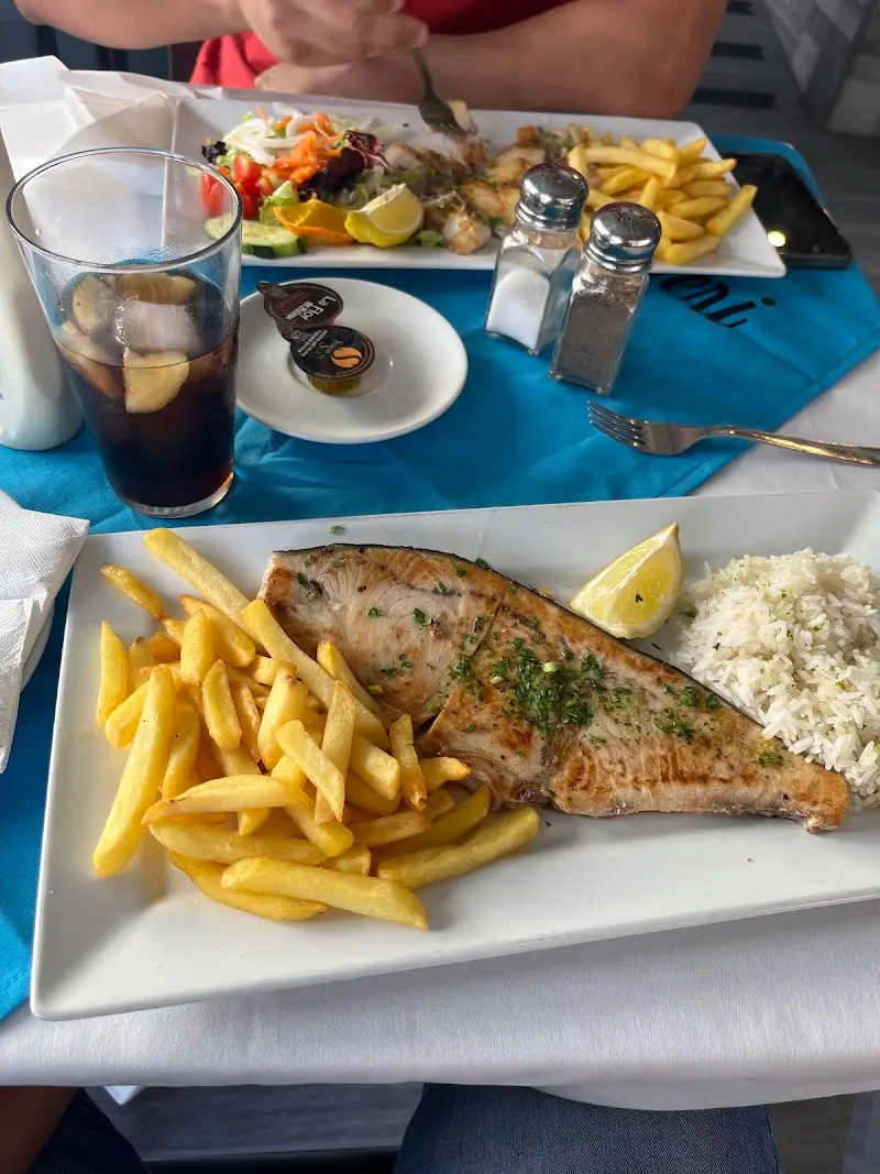 Pescado a la plancha con patatas fritas, arroz blanco y limón en el Restaurante Meri