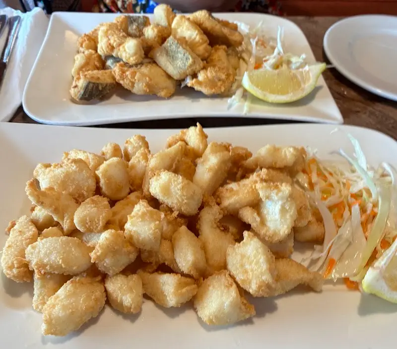Calamares fritos y pescado frito en adobo con ensalada de col y limón