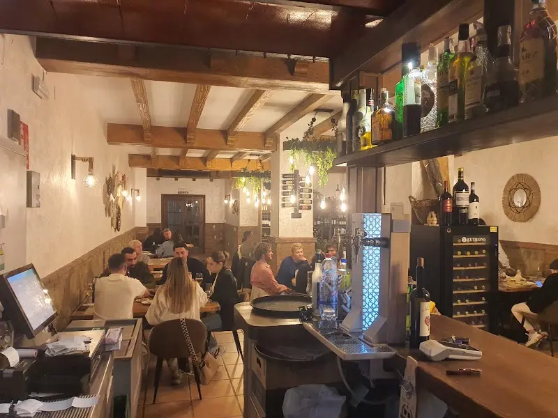 Barra y comedor lleno de clientes por la noche en Mogador Nerja