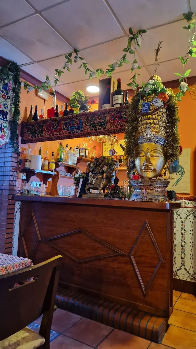 Barra de madera con una gran cabeza dorada de Buda y figuras decorativas