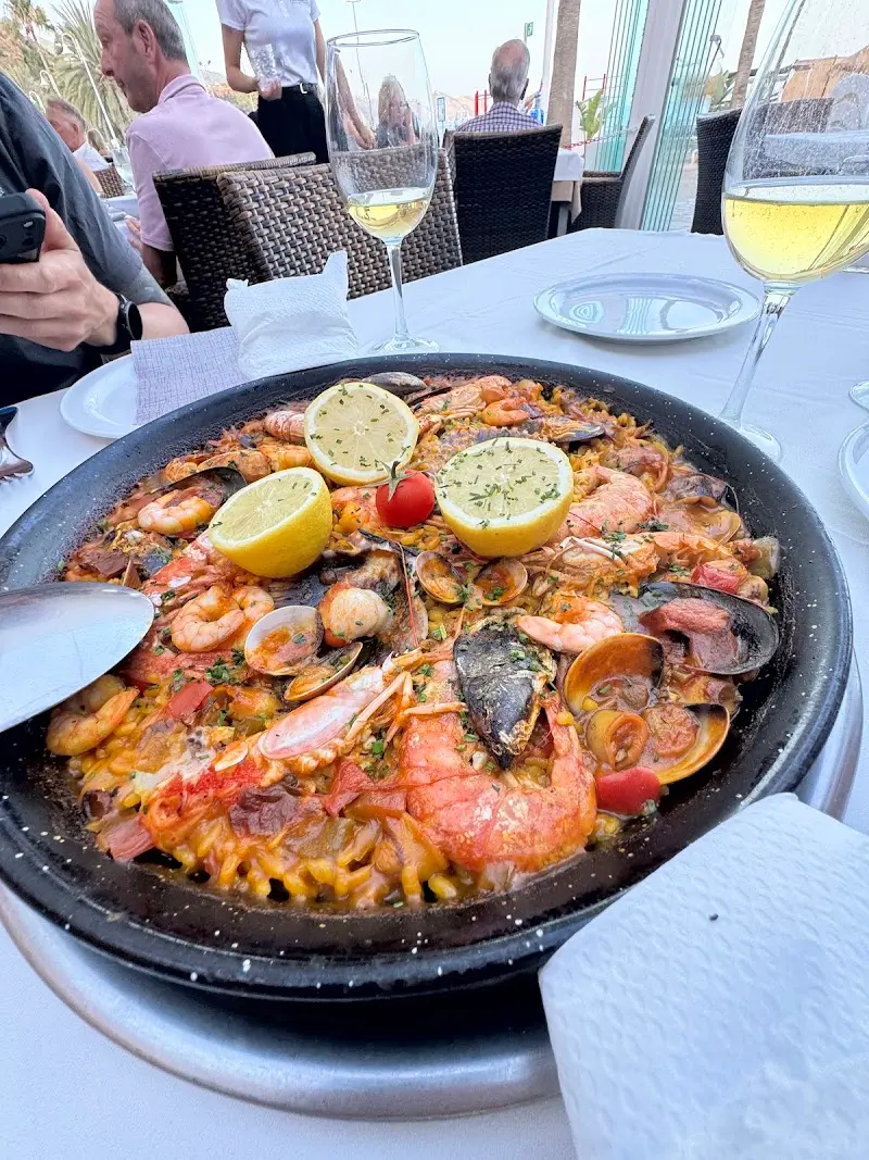 Paella de marisco con gambas, almejas, mejillones y limón en la mesa
