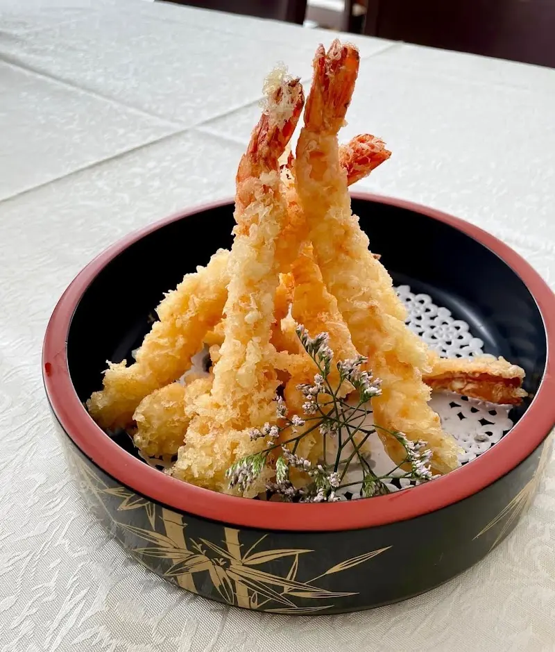 Langostinos en tempura servidos en un cuenco lacado negro y rojo