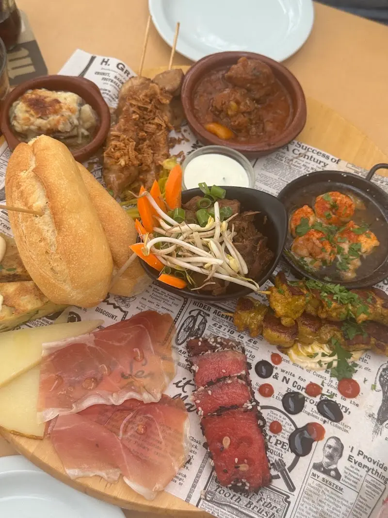 Tabla de tapas variadas en Tapas Plaza: jamón, queso, brochetas, gambas, guiso y pan