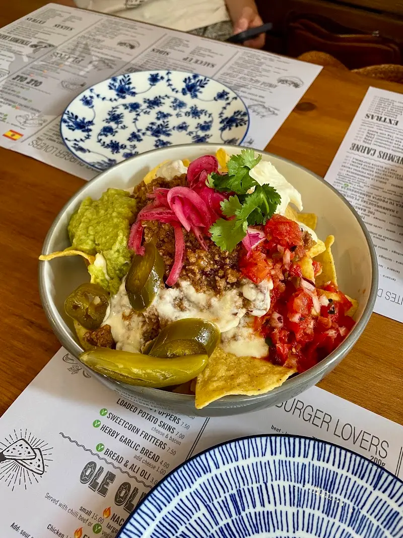 Nachos con carne picada, guacamole, pico de gallo, jalapeños y cebolla encurtida