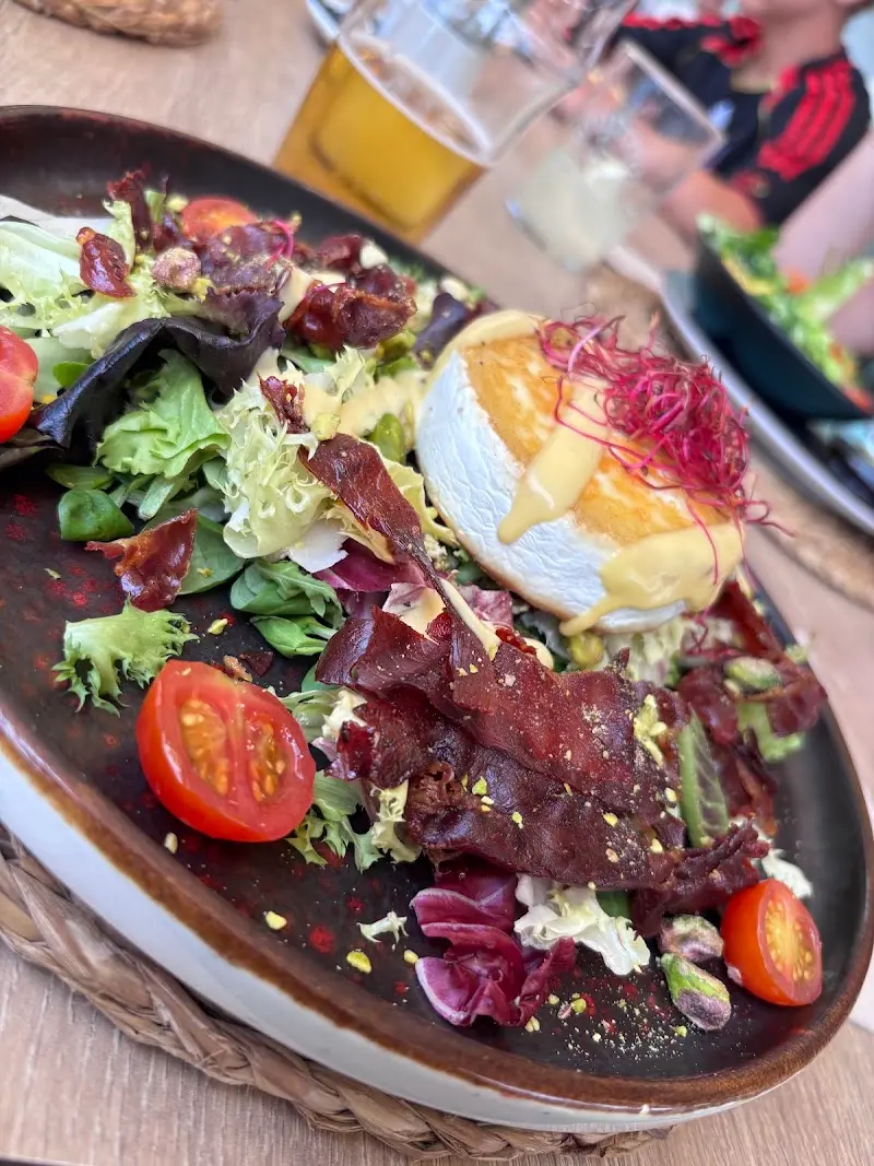 Ensalada de queso de cabra gratinado con cecina crujiente, tomates cherry y pistachos