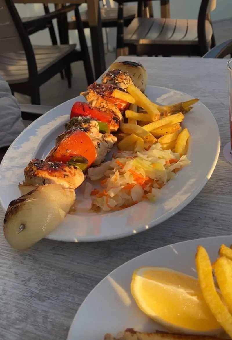 Brocheta de pollo con pimientos y cebolla, patatas fritas y ensalada de col