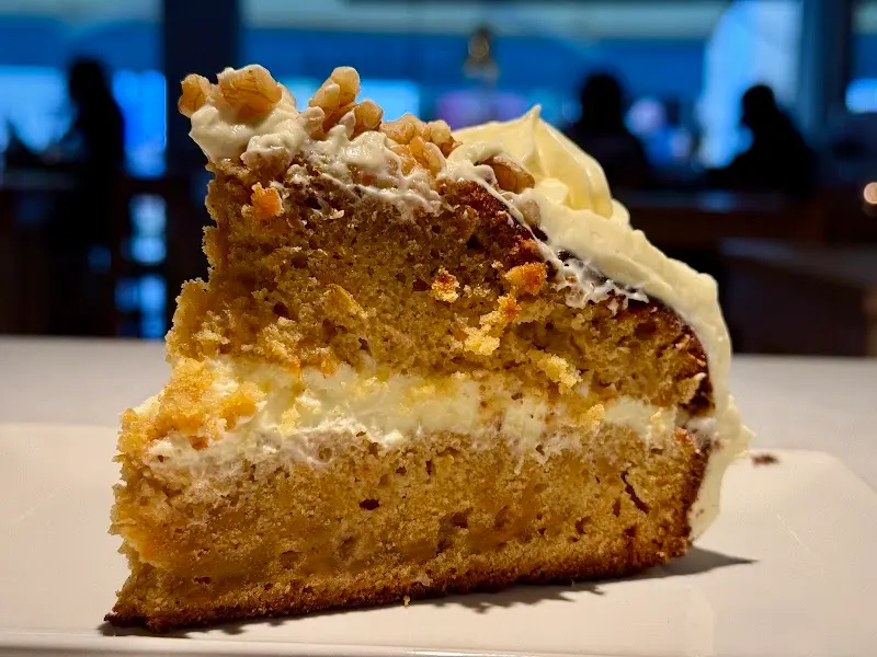 Porción de tarta de zanahoria con crema de queso y nueces