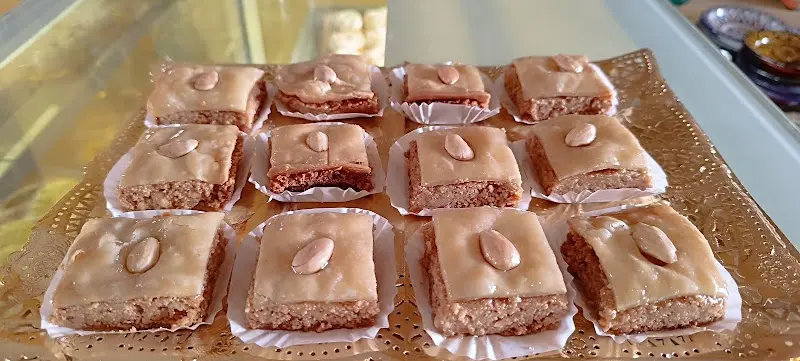 Bandeja de pasteles marroquíes glaseados, cada uno con una almendra encima