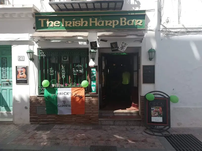 Fachada de The Irish Harp Bar decorada para San Patricio con bandera irlandesa y globos verdes