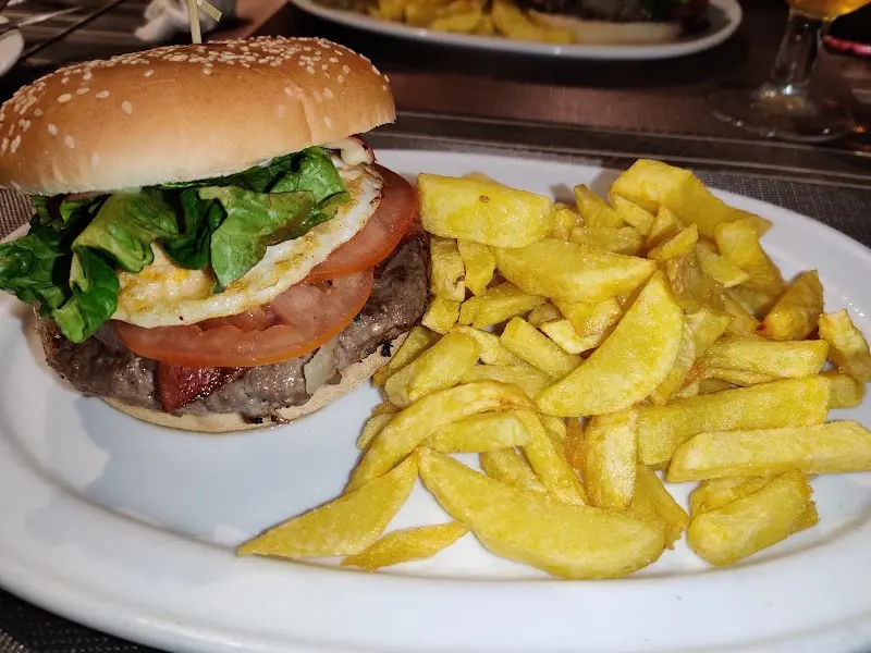 Hamburguesa con huevo frito, beicon, tomate y lechuga con patatas fritas caseras