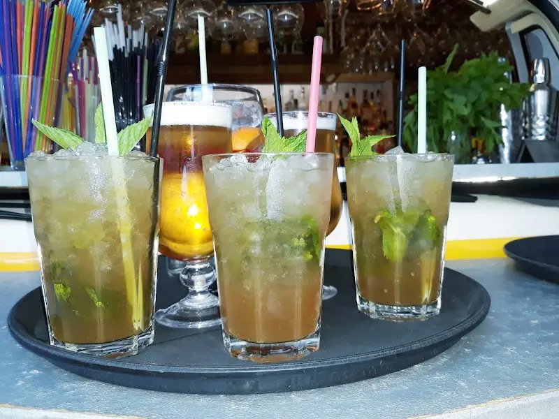 Mojitos con hierbabuena y cócteles en una bandeja sobre la barra
