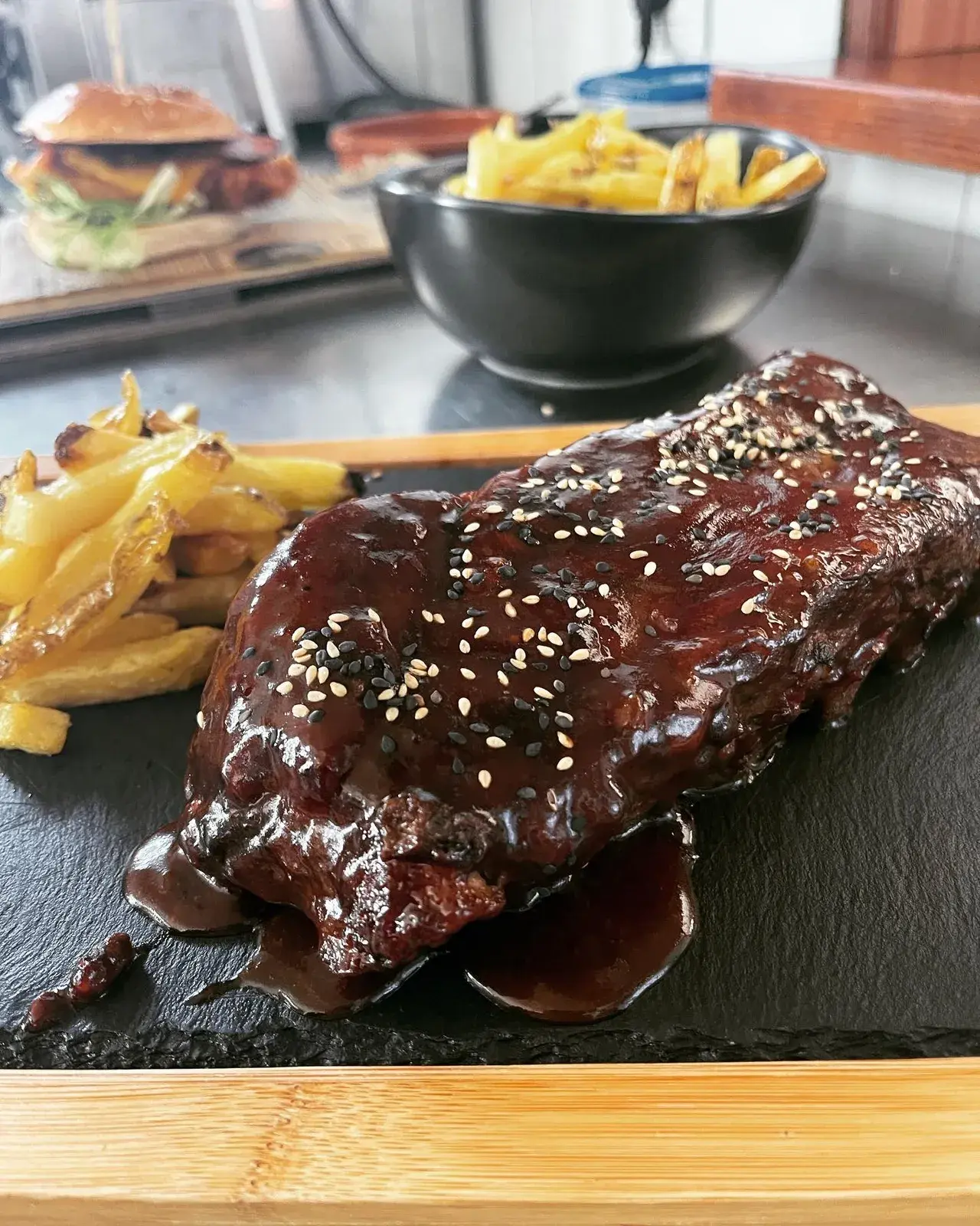 Costillas glaseadas con sésamo y patatas fritas en Food Karma Gastro