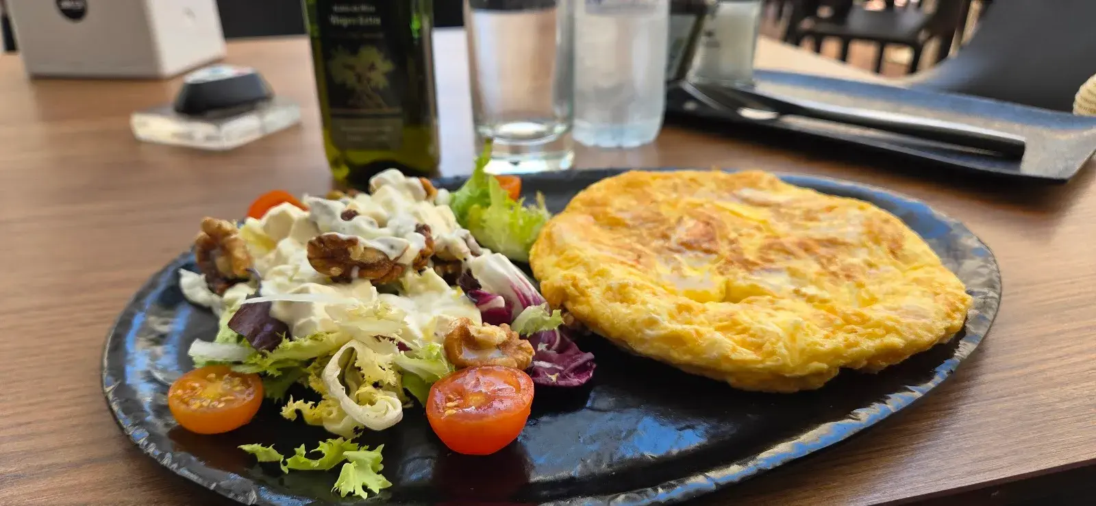 Tortilla de patatas con ensalada de nueces y tomates cherry en el Kronox Café